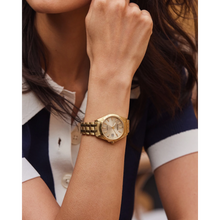 Load image into Gallery viewer, Gold wristwatch on a person's wrist with a blurred background