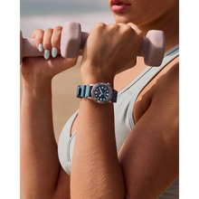 Load image into Gallery viewer, Person lifting weights with a watch on wrist, beach background