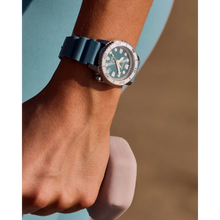 Load image into Gallery viewer, Close-up of a wrist wearing a watch with a blue strap against a blurred background