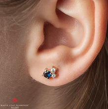 Load image into Gallery viewer, Close-up of an ear wearing a diamond earring with a blue gemstone, brand 'Maple Leaf Diamonds' visible.