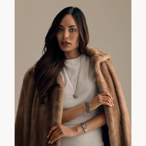 Woman wearing a fur coat over a plain background