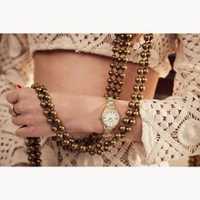 Load image into Gallery viewer, Gold watch and beads on a person wearing a lace top
