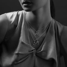 Load image into Gallery viewer, Woman wearing multiple necklaces with pendant details on a dark background
