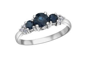 White gold ring with three blue gemstones and small diamonds on a white background