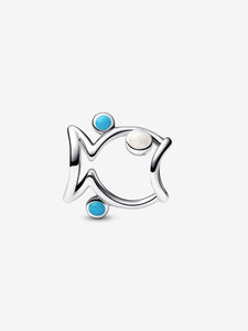 Silver fish-shaped charm with blue and clear gemstones on a white background