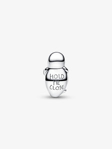 Silver charm with 'Hold Me Close' text on a white background