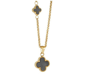 Gold plated necklace with black clover pendants on a white background