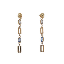 Load image into Gallery viewer, A pair of gold drop earrings featuring rectangular gold-tone links, clear rhinestones, and light blue rectangular crystals, shown against a plain white background.
