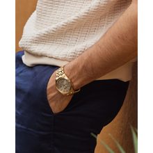 Load image into Gallery viewer, Gold watch on a person&#39;s wrist with a neutral background
