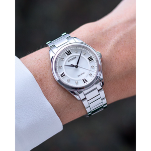 Silver Citizen watch on a wrist with a blurred background