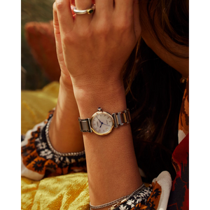 Close-up of a wrist wearing a vintage-style watch with a blurred background