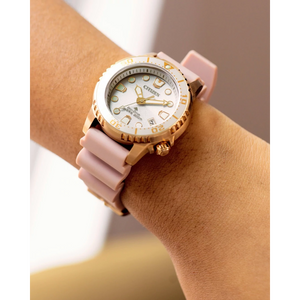 Wrist wearing a pink and gold watch with a white face.