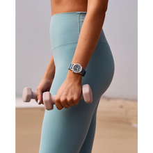 Load image into Gallery viewer, Person wearing light blue leggings and holding a pink dumbbell, with a neutral background
