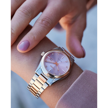 Load image into Gallery viewer, Close-up of a wrist wearing a silver and rose gold watch with a pink face.
