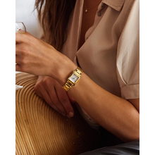 Load image into Gallery viewer, Gold watch on a wrist with a neutral background
