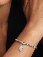 Load image into Gallery viewer, Silver bracelet with a coffin charm on a wrist against a dark background
