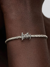 Load image into Gallery viewer, Silver bracelet with &#39;family&#39; charm on a wrist
