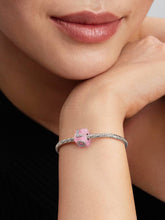 Load image into Gallery viewer, Close-up of a woman's hand wearing a bracelet with a pink bead.

