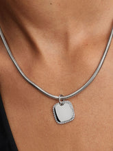Load image into Gallery viewer, Silver necklace with a square pendant on a person&#39;s neck
