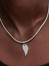 Load image into Gallery viewer, Silver necklace with an angel wing-shaped pendant on a person
