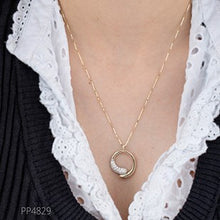 Load image into Gallery viewer, Necklace with a gold ring pendant worn by a person, with a white lace garment and black cardigan.
