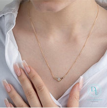 Load image into Gallery viewer, Necklace with a chevron shaped pendant worn by a person, with a close-up of the necklace and hand.
