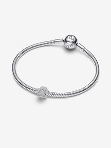 Silver bracelet with a heart charm on a white background