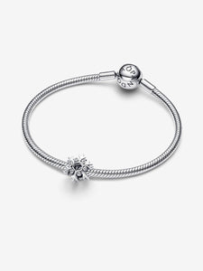 Silver bracelet with a snowflake charm on a white background