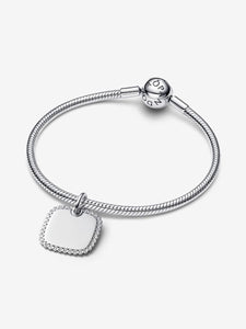 Silver bracelet with a square-shaped charm on a white background
