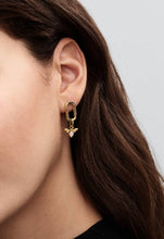 Load image into Gallery viewer, Close-up of a person wearing a gold toned earring with a small pendant on a plain background
