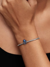 Load image into Gallery viewer, Silver bracelet with a blue charm on a wrist against a neutral background
