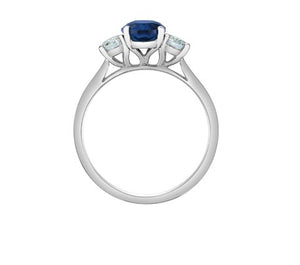 White gold ring with a blue gemstone and two smaller clear stones in profile on a white background