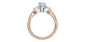 Rose gold ring with three diamond stones on a white background