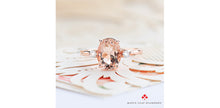 Load image into Gallery viewer, Rose gold ring with a pink gemstone on a white shell, Maple Leaf Diamonds logo visible.
