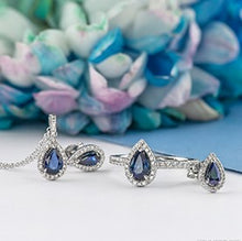 Load image into Gallery viewer, White gold jewelry set with blue gemstones on a floral background
