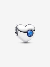 Load image into Gallery viewer, Heart-shaped silver charm with a blue gemstone on a white background
