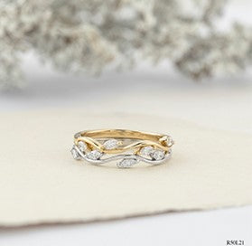 Two gold rings with intricate designs on a white surface.