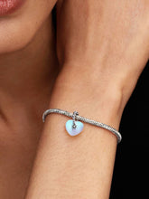 Load image into Gallery viewer, Bracelet with a heart-shaped charm on a wrist against a black background
